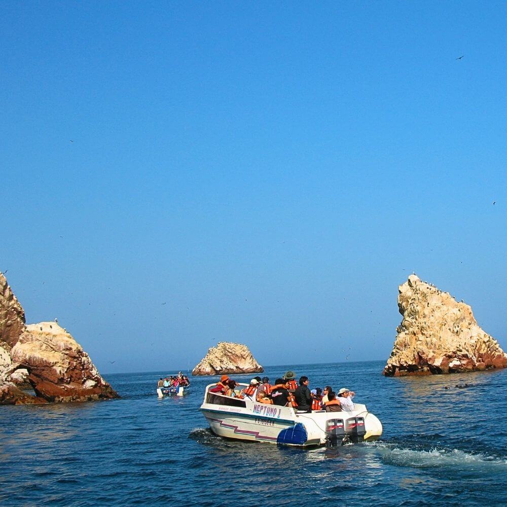 Boat tour to the Ballestas Islands in Paracas with tourists exploring Peru’s famous marine wildlife sanctuary during the Paracas and Nazca Lines Tour.