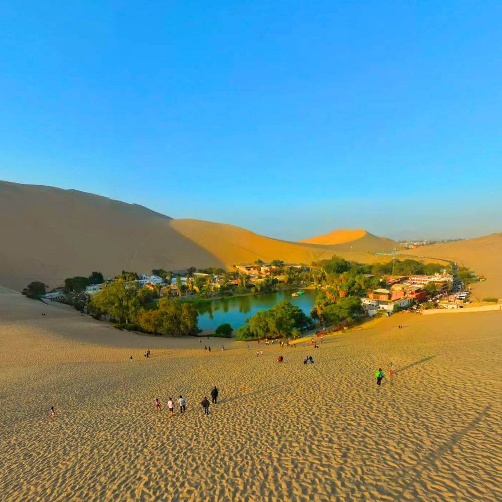 Panoramic view of the Huacachina Oasis surrounded by giant sand dunes in Ica Peru