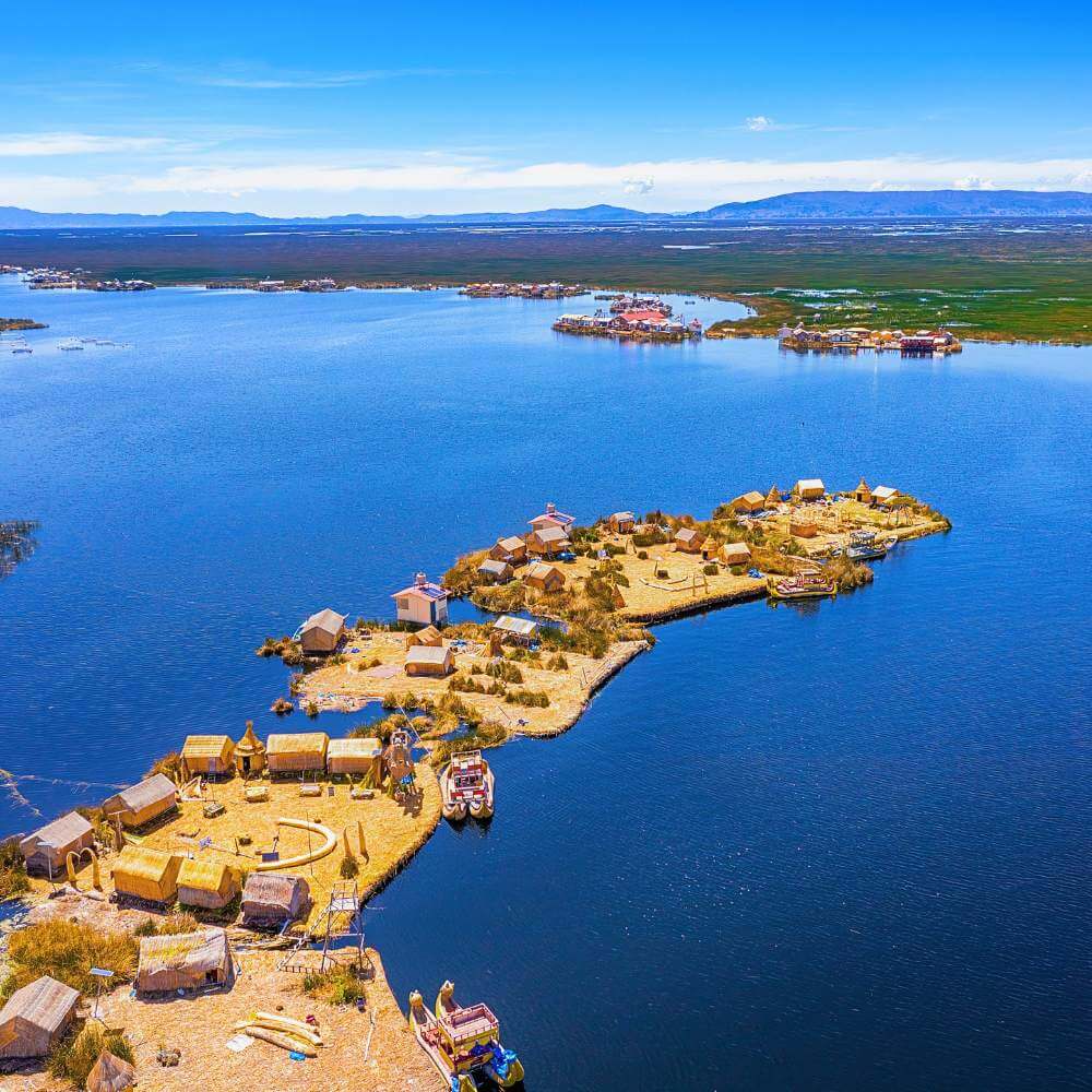 Aerial view of the Uros Floating Islands on Lake Titicaca, showcasing traditional reed islands during a Lake Titicaca Full Day Tour from Puno.