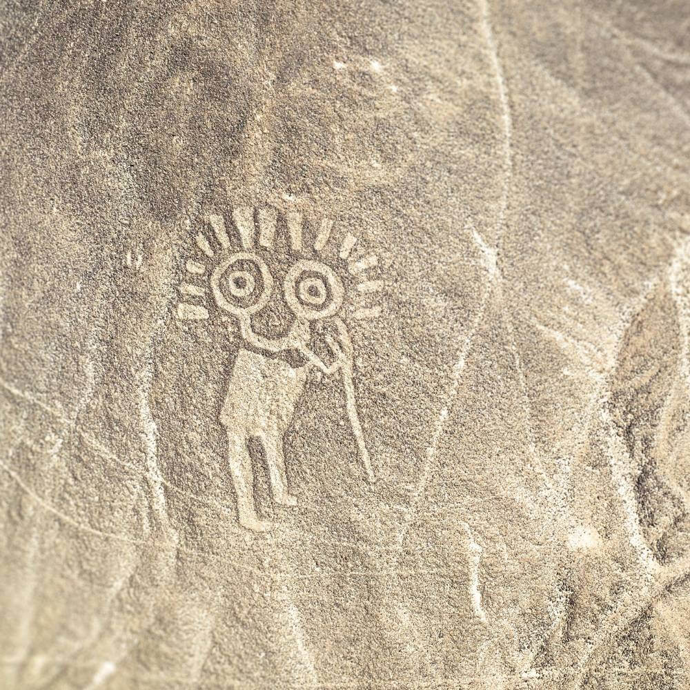 The mysterious Astronaut geoglyph carved into a hillside overlooking the Nazca Desert, one of Peru's most intriguing ancient figures.