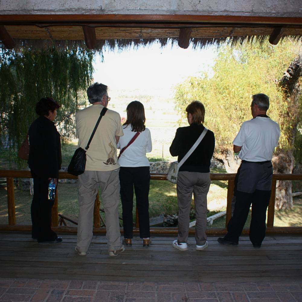 Travelers enjoying the peaceful gardens of the Founder's Mansion during the Arequipa Countryside Tour, surrounded by colonial architecture and scenic countryside views.