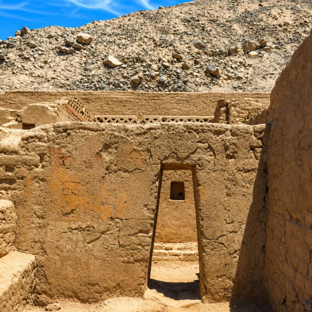 Puerta histórica inca dentro de Tambo Colorado con paredes de adobe originales y arquitectura trapezoidal tradicional en Perú.
