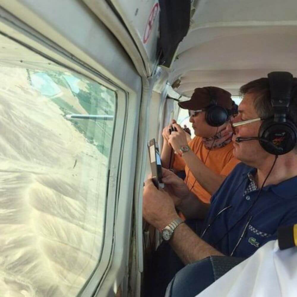 Passengers photographing ancient geoglyphs through the window during a Nazca Palpa Lines Flight in Peru.