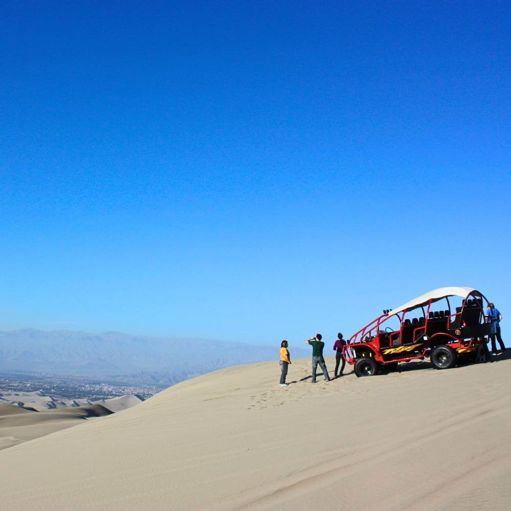Offroad Dune Buggy, der an einem malerischen Aussichtspunkt mit Blick auf die Huacachina-Wüste in Peru geparkt ist.