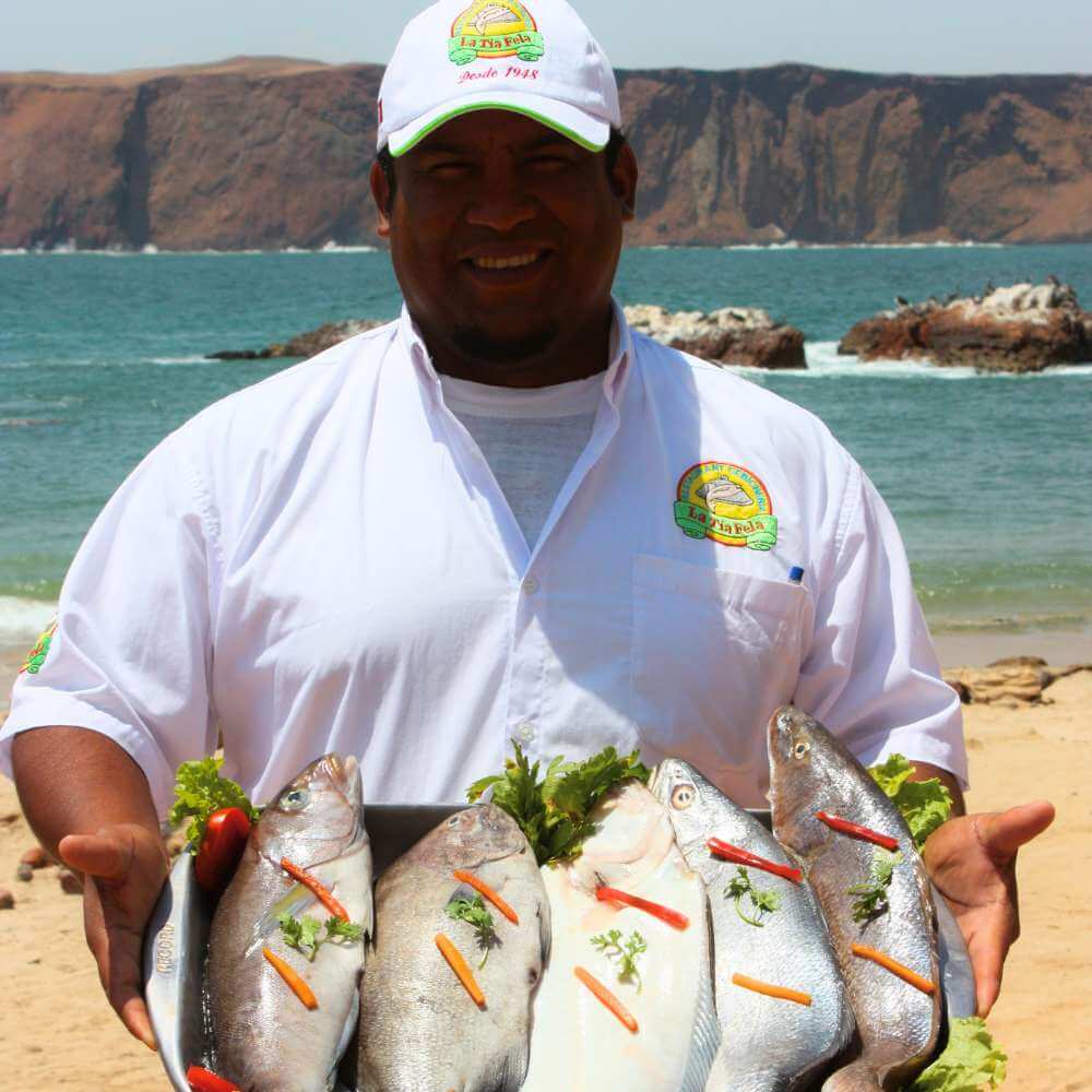 Frische Meeresfrüchte, die in einem Restaurant am Wasser im Fischerdorf Lagunillas während einer Paracas-Bucht-Tour, Peru, zubereitet werden.